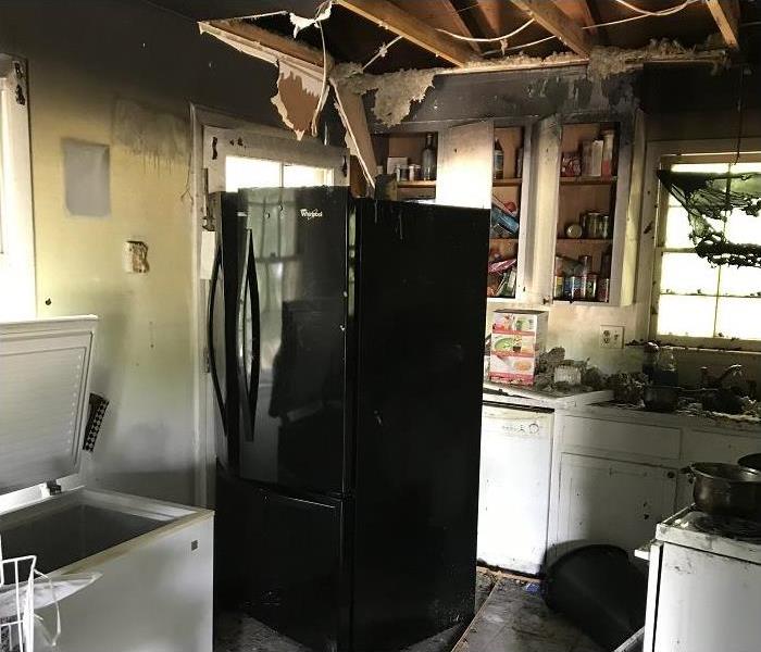 Fire damaged kitchen; smoke and soot on walls and ceiling