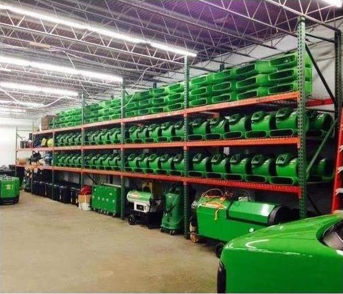 Green equipment stored on shelves in warehouse 