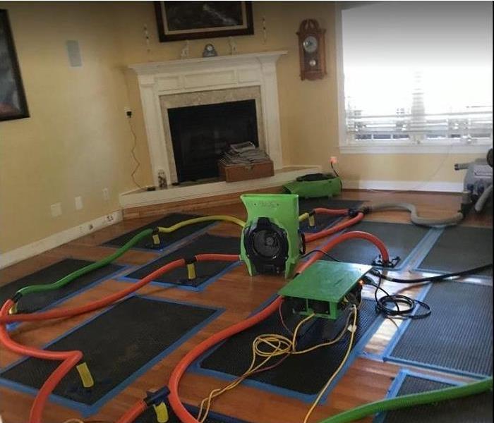 SERVPRO drying equipment being used on water damaged living room floor